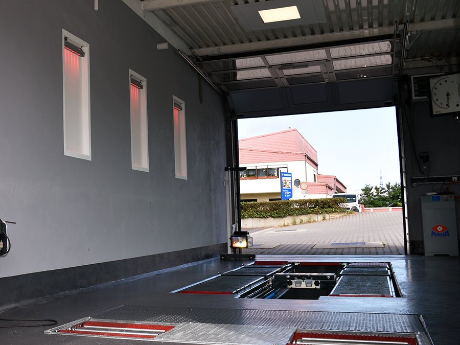 Prüfhalle des Ingenieurbüros Wolk mit geöffnetem Rolltor und bodenbündiger Prüftechnik